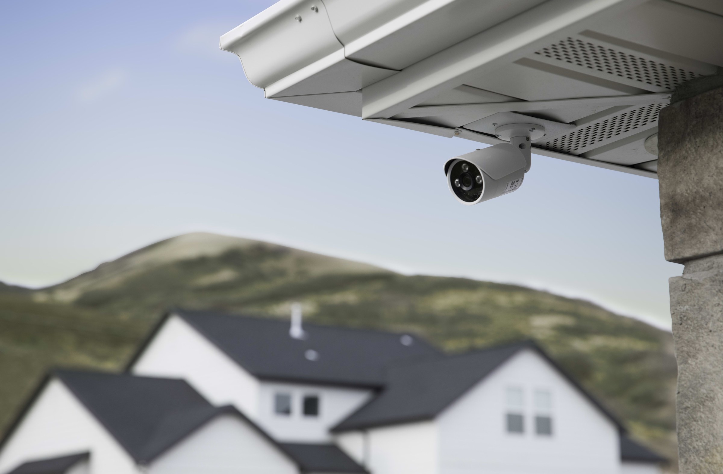 Control4 Luma surveillance camera mounted under the eave of a house
